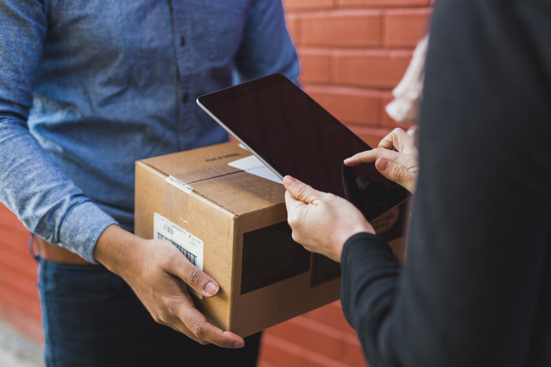 Nahaufnahme einer Paketübergabe bei einer Lieferung 